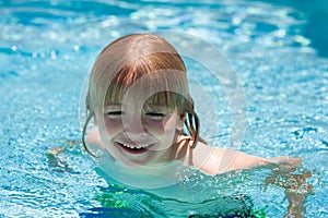 Happy child playing in swimming pool. Summer kids vacation.