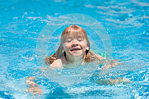 Happy child playing in swimming pool. Summer kids vacation.