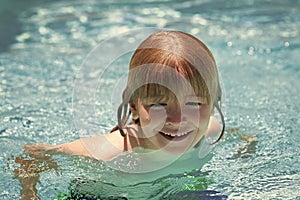 Happy child playing in swimming pool. Summer kids vacation.