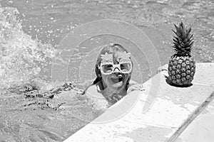 Happy child playing in swimming pool. Summer kids vacation. Little kid boy relaxing in a pool having fun during summer