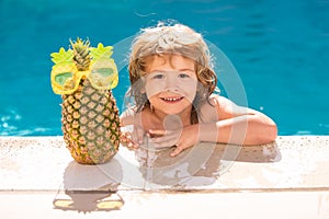 Happy child playing in swimming pool. Summer kids vacation. Summer pineapple fruit.