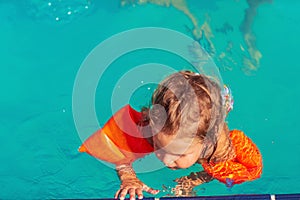 Happy child playing in swimming pool. Summer vacation