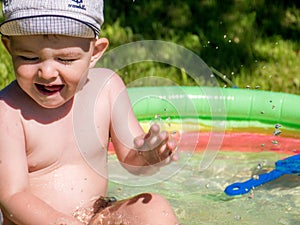 Happy child playing in swimming pool. Summer vacation