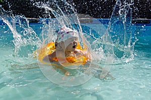 Happy child playing in swimming pool. Summer vacation concept