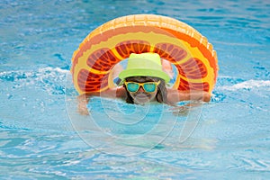 Happy child playing in swimming pool. Summer vacation concept. Summer kids portrait in sea water on beach.