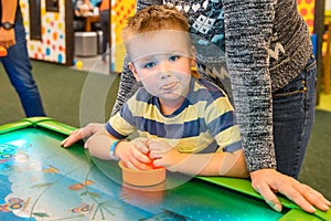 Happy child playing table air hockey