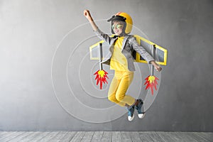 Happy child playing with toy jetpack photo