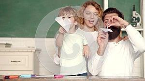 Happy child playing with toy paper airplane. Children education and pupils education. First day at school. Back to
