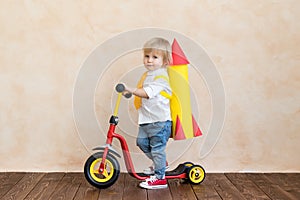 Happy child playing with toy rocket at home