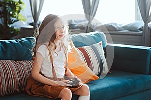 Happy child playing video games with gamepad at home