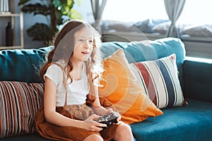 Happy child playing video games with gamepad at home