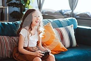 Happy child playing video games with gamepad at home