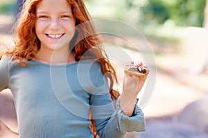 Happy, child and portrait of eating smores outdoor, camping and relax at barbecue with dessert or cookie. Girl, smile