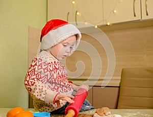 Happy child is preparing the dough, bake cookies in the kitchen