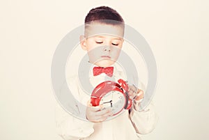 Happy child with retro clock in bow tie. tuxedo kid. Happy childhood. little boy with alarm clock. Time to relax. Party