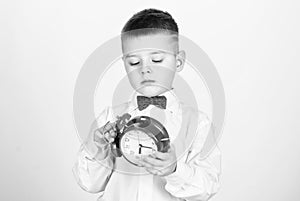 Happy child with retro clock in bow tie. tuxedo kid. Happy childhood. little boy with alarm clock. Time to relax. Party