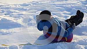 A happy child rides in snowtube on a snowy hill