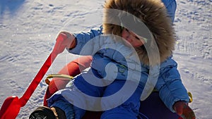 A happy child rides in snowtube on a snowy hill