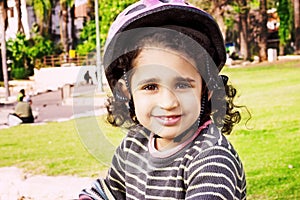 Happy child riding a bike in outdoor. Cute kid in safety helmet biking outdoors.