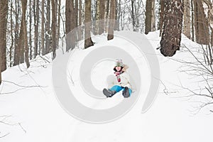 Happy child riding down a snowy hill