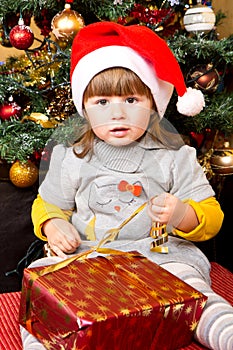 Happy child in Santa hat opening Christmas gift box