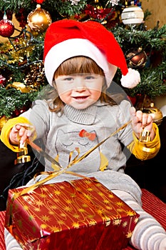 Happy child in Santa hat opening Christmas gift box