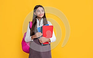 happy child with school backpack and handbook on yellow background