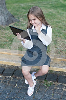 Happy child in school uniform learn online using digital tablet computer for reading, elearning
