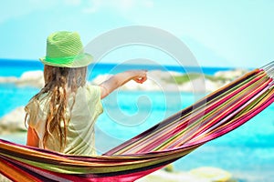 Happy child by the sea on hammock in greece background