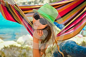 Happy child by the sea on hammock in greece background