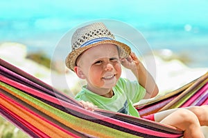 A happy child by the sea on hammock in greece background