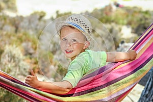 A happy child by the sea on hammock in greece background