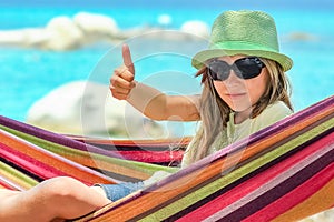 A happy child by the sea on hammock in greece background