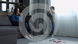 Happy child singing into microphone toy at home