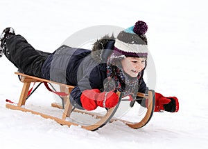 Happy child on sledge in winter