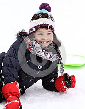 Happy child on sledge in winter