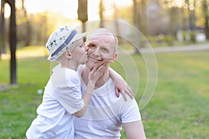 Happy child son kissing father