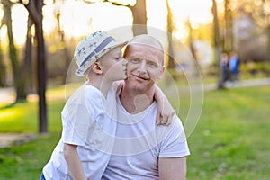 Happy child son kissing father