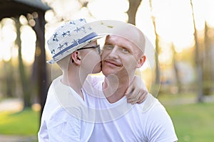 Happy child son kissing father