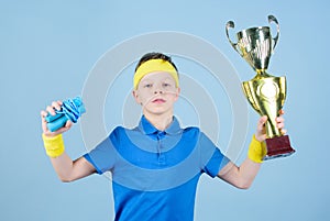 Happy child sportsman hold champion cup trophy. Fitness and diet. Energy. Gym workout of teen boy winner. Success trophy