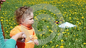 Happy child in a spring glade in dandelions with his family.