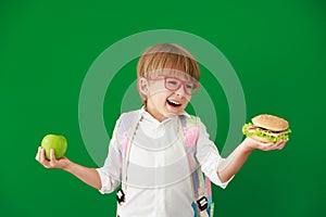 Happy child student against green chalkboard