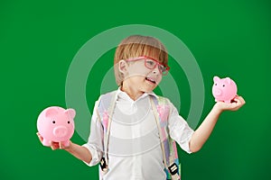 Happy child student against green chalkboard