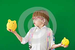 Happy child student against green chalkboard