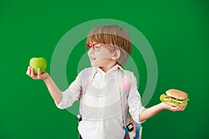 Happy child student against green chalkboard