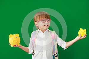 Happy child student against green chalkboard