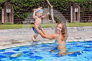 Happy child swim with beautiful mother in pool