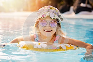 happy child in swimming pool with inflatable ring at resort hotel water park