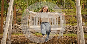 happy child on swing. kid swinging outdoor. teen girl having fun on playground.