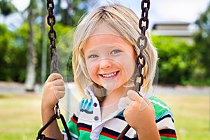 Happy child on a swing in play ground